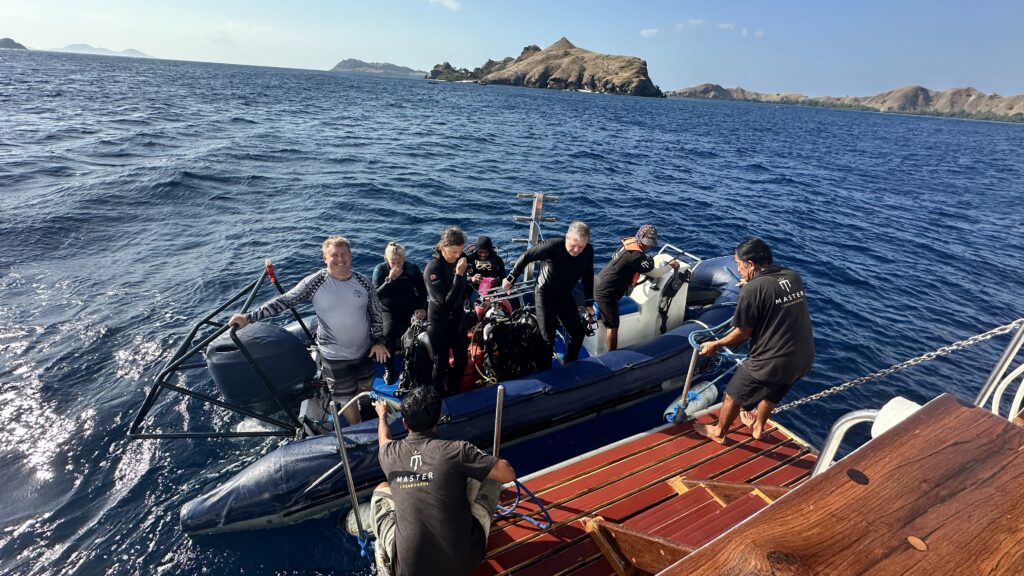 Scuba divers boarding a panga to travel from a liveaboard to a dive site