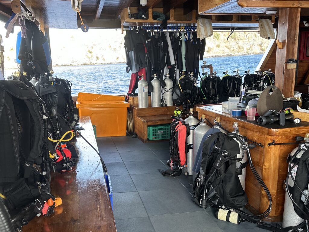 Scuba diving equipment organized at individual stations on a liveaboard dive deck