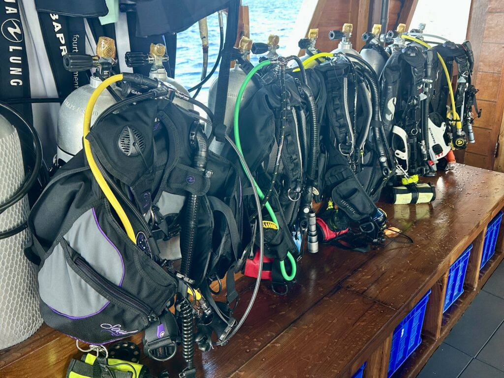 Scuba BCDs and regulators assembled on tanks at liveaboard dive stations